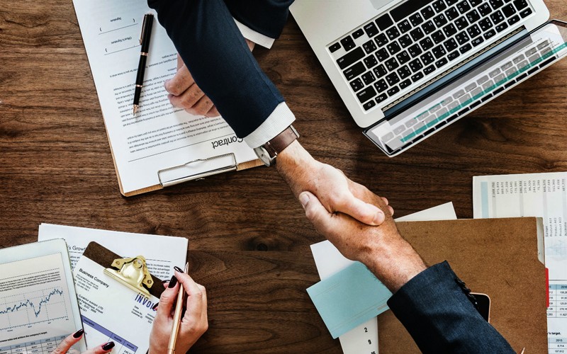 Best HR - OUTSOURCE - Two Business People Shaking Hands Over Desk